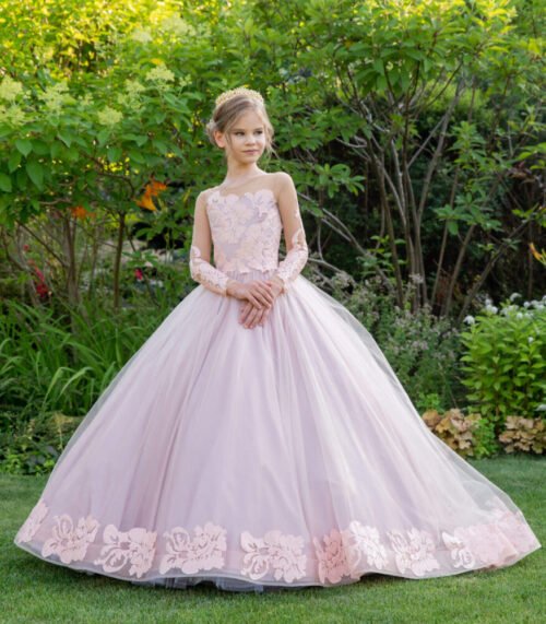 Elsie pastel pink ball gown with floral lace bodice, long lace sleeves, and layered tulle skirt—styled outdoors in a garden with blooming flowers and greenery for weddings, fantasy shoots, and royal-themed celebrations.