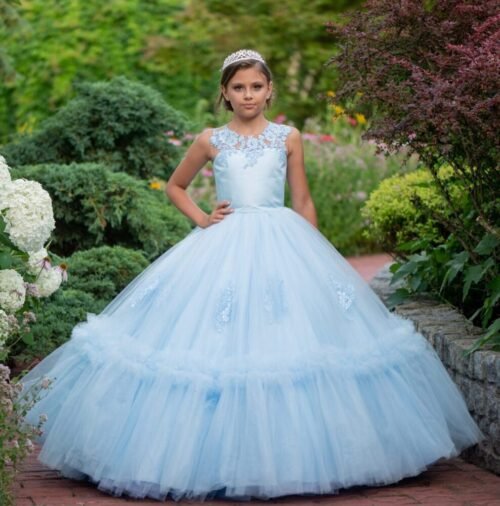 Isabella light blue ball gown with lace bodice and layered tulle skirt—styled outdoors on a brick pathway with tiara and garden backdrop for weddings, fantasy shoots, and royal-themed celebrations.